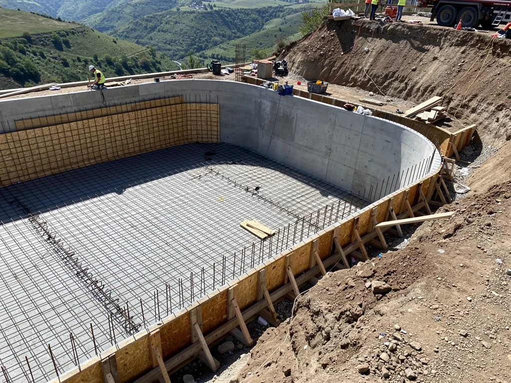 Chantier de piscine à débordement : coque béton et goulotte en cours de construction